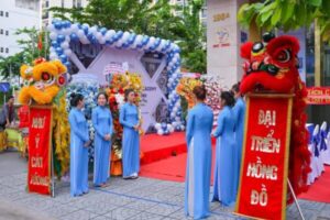 PG lễ khai trương mặc áo dài đỏ cầm băng cắt – kết hợp cùng ông Địa